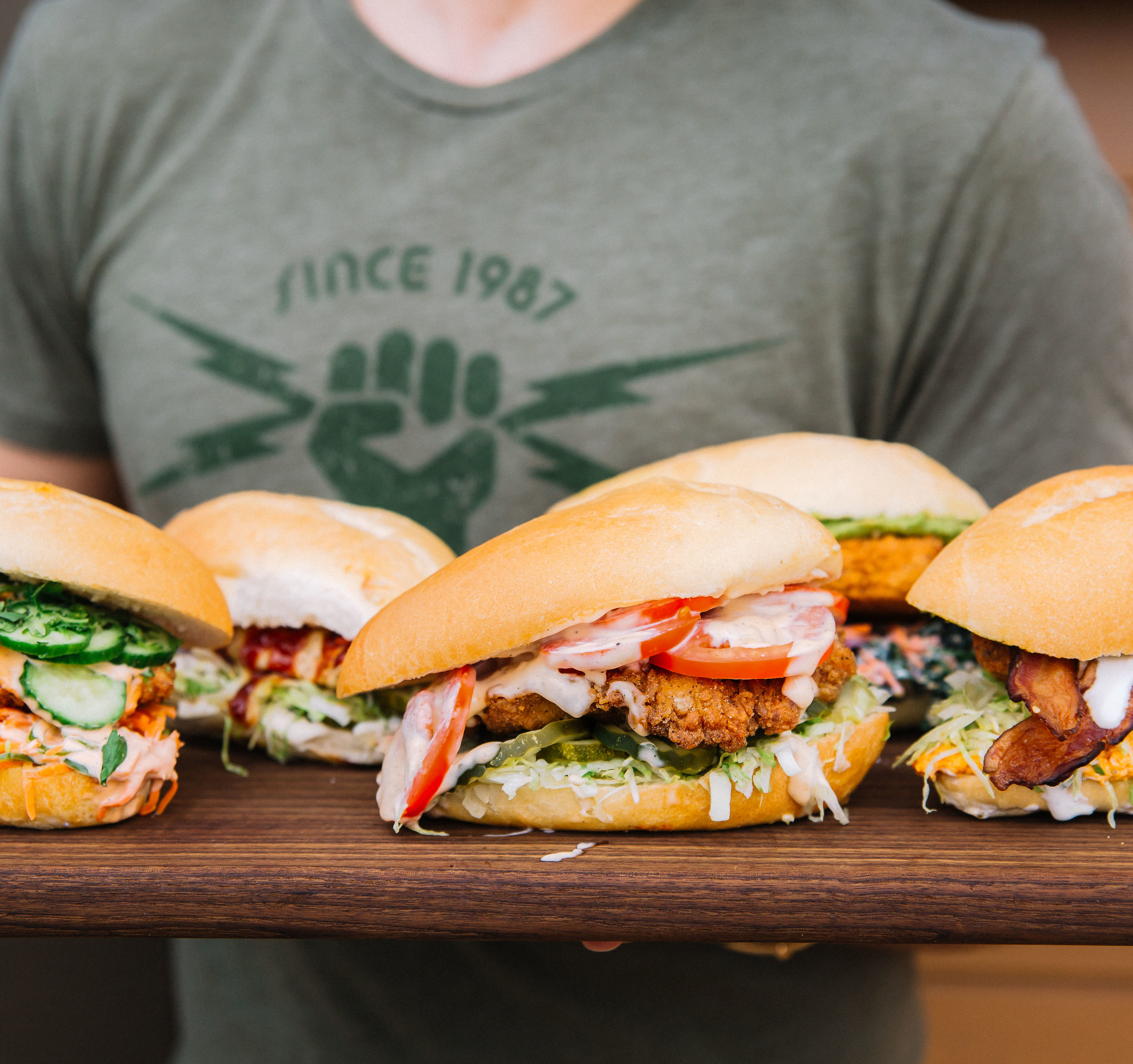 Person holding a platter of Starbird Chicken sandwiches